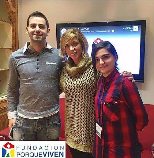Tres personas sonríen ante la cámara junto a una pantalla, en un acto Fundación PorqueViven de cuidados paliativos en Madrid