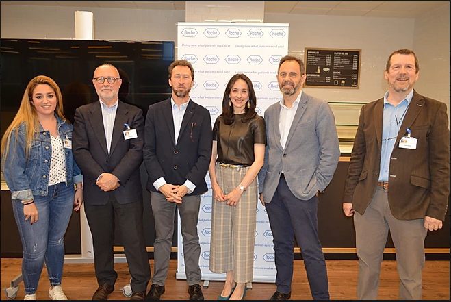 Seis personas del equipo posan sonrientes ante el fondo corporativo en un evento