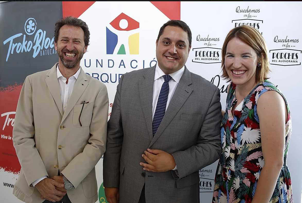 Tres personas sonríen frente a un fondo de logos, entre ellos , en un evento