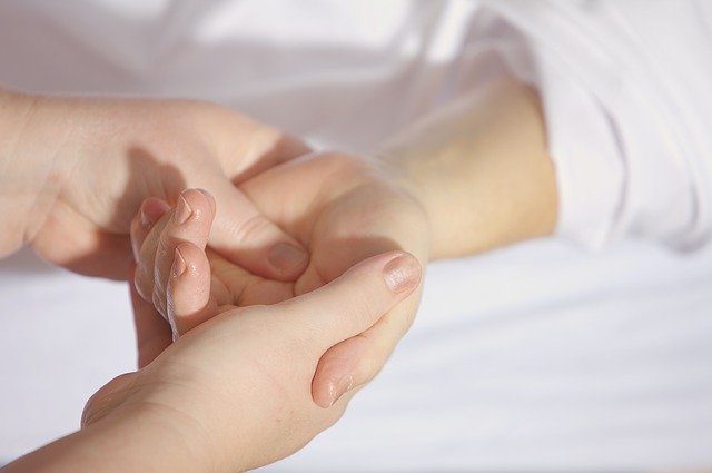 Primer plano de unas manos entrelazadas: un cuidador Fundación porqueViven brinda apoyo y consuelo a un niño en Madrid