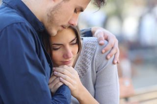Una pareja se abraza en busca de consuelo, reflejando el apoyo humano que ofrece en Madrid