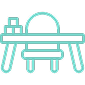 Ilustración en línea color teal de un escritorio y silla, con tres bloques apilados, evocando el espacio de juego en de Madrid dedicada a cuidados paliativos pediátricos